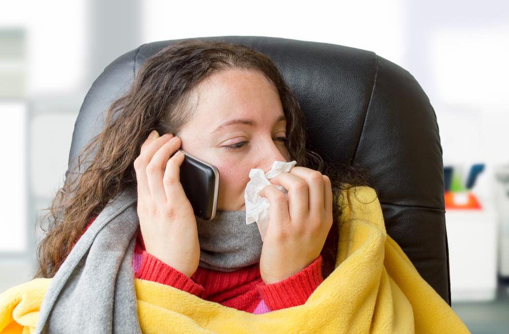sick woman in blanket sitting with tissue